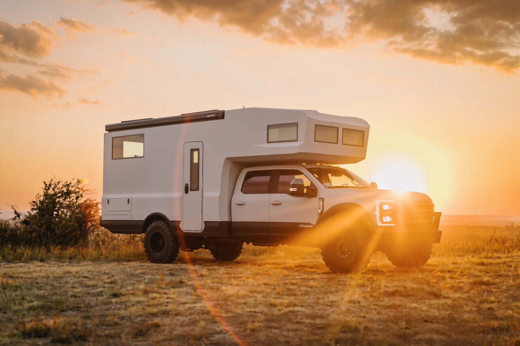 White expedition truck camper at sunset